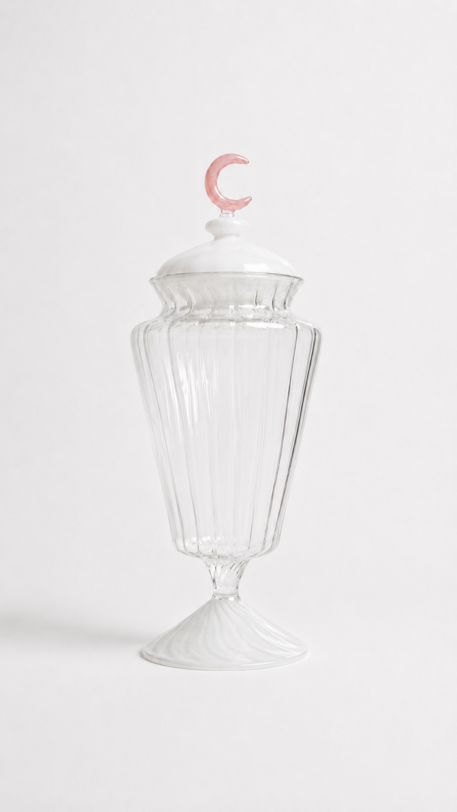 Transparent blown glass candy jar with a pink crescent moon lid inspired by traditional Ramadan fanoos lanterns, isolated on a white background.
